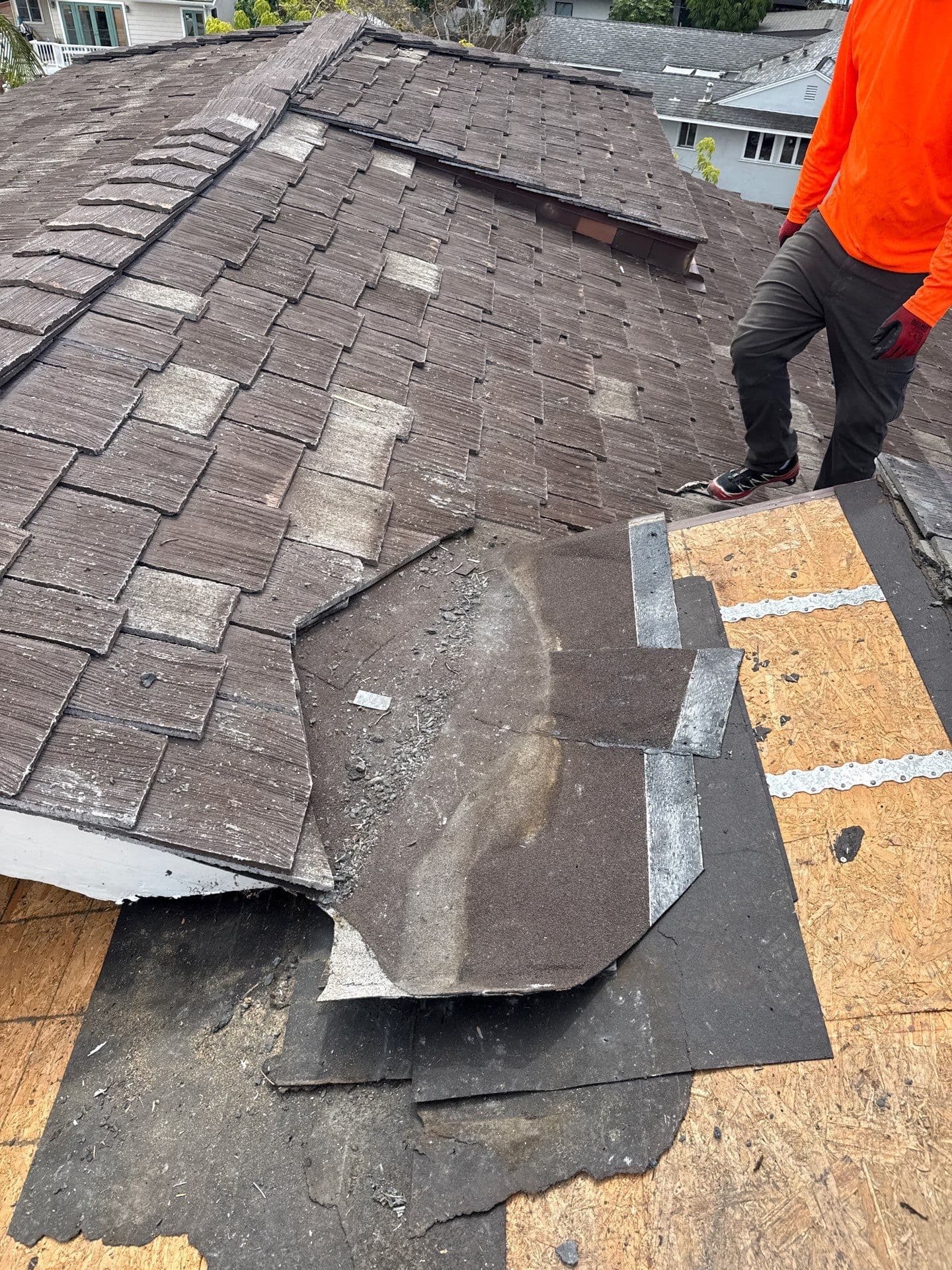 Worn roof with exposed decking before full replacement